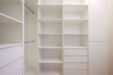 White wardrobe with shelves in the dressing room