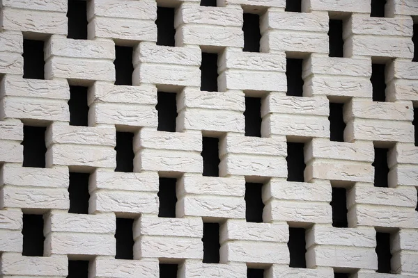 Checkerboard laying of white bricks outside the building close-up