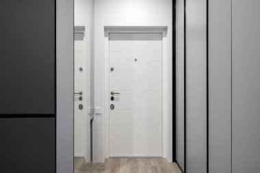 Modern bir apartmanın içindeki beyaz giriş kapısı.