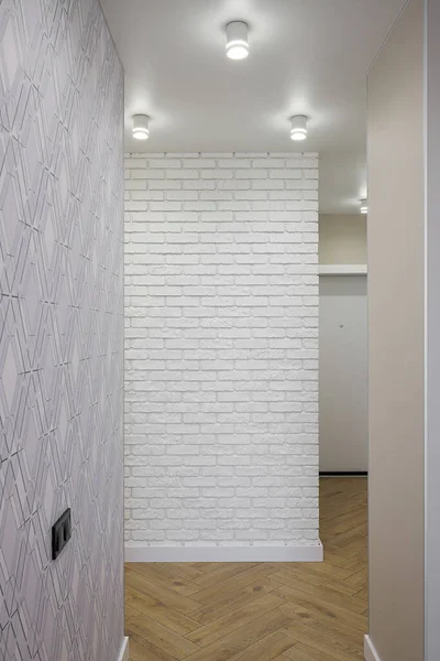 Hallway with white brick wall in the apartment interior