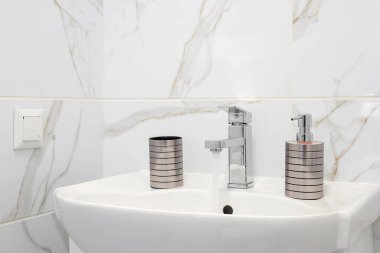 Beyaz seramik lavabolu krom musluk.