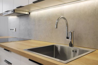 Faucet and steel sink in the kitchen