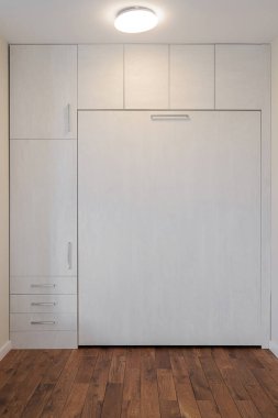 Odanın içindeki ahşap beyaz gardırop.