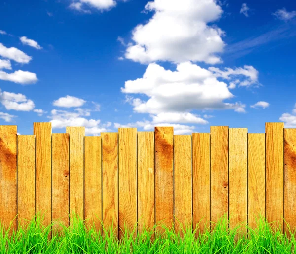 Wooden fence with green grass and field — Stock Photo, Image