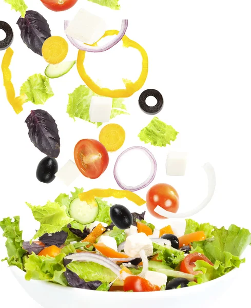 Falling fresh vegetable on plate with salad — Stock Photo, Image