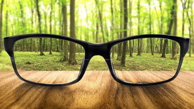 Clear forest in glasses on the background of blurred forest clipart