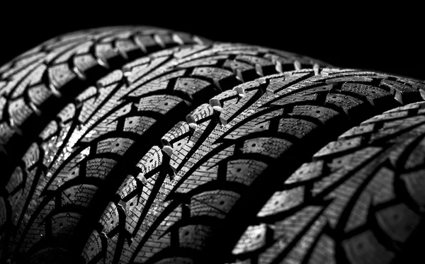 Winter car tyre on a black background