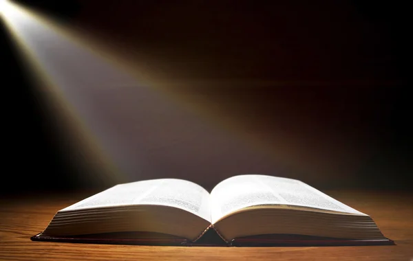 ahşap masa ışık ışını ile eski bir kitap