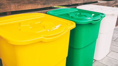 Arka bahçedeki çöpleri ayırmak için üç çöp kovası.