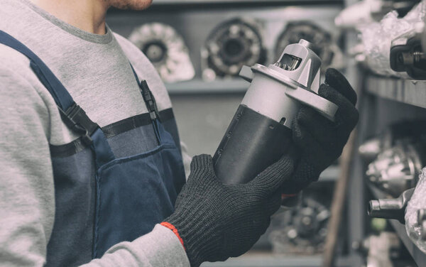 Рабочий ищет необходимую запчасть для автомобиля 