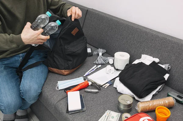 Young Man Packing Bag Documents Water Food First Aid Kit — Stock Photo, Image