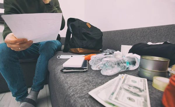 Joven Empacando Bolsa Con Documentos Agua Comida Botiquín Otros Artículos — Foto de Stock