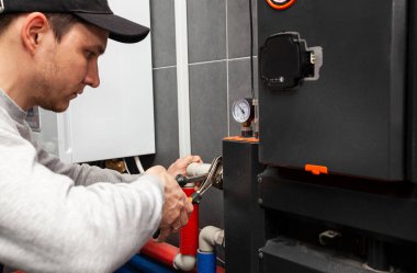 Tesisatçı kazan dairesindeki ısıtma sisteminde boru fındığı vidaladı.