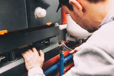 Tesisatçı kazan dairesindeki ısıtma sisteminde boru fındığı vidaladı.