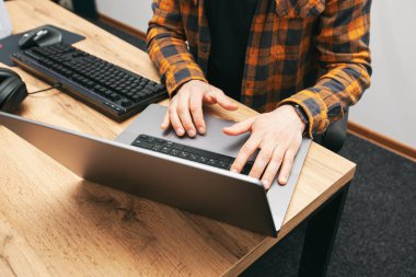 The guy in office working with the laptop and pc in the same time