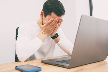 Young freelancer guy tired after working on laptop