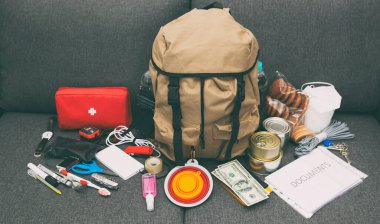 The packed backpack with items needed for evacuation. Emergency kit. Set of necessary things in case of accident or disaster