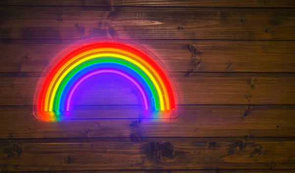 led neon rainbow hanging on the wooden wall