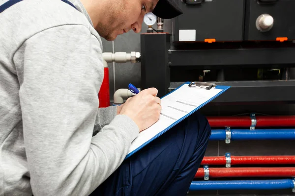 Technician Servicing Holding Clipboard Inspecting Heating System Boiler Room — 图库照片