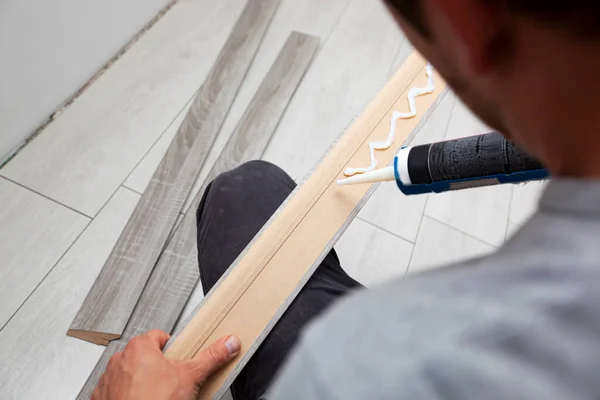 Worker Applies Glue Baseboard Installing Floor — 스톡 사진