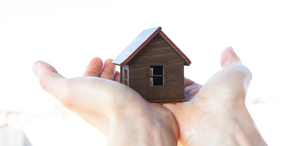 Mano Del Hombre Sostiene Casa Madera Contra Cielo — Foto de Stock