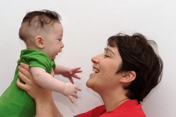 Lindo bebé sostenido por su sonriente madre vista de perfil — Foto de Stock