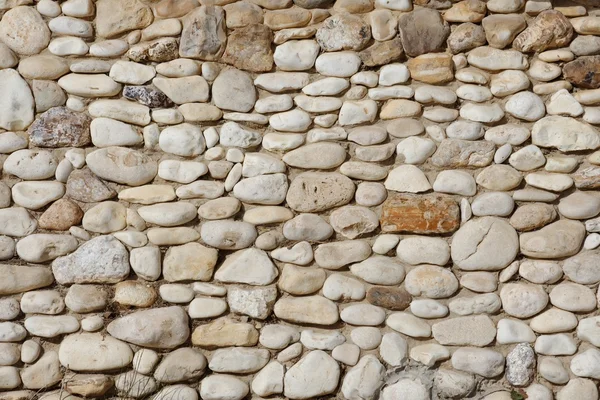Textuur van stenen muur gebouwd van onregelmatige steentjes — Stockfoto