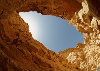 Blue sky seen from the bottom of a desert canyon clipart