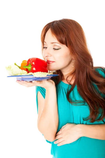 Una donna incinta con un piatto di verdure — Foto Stock