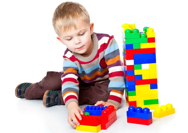 Un chico divertido está jugando con lego — Foto de Stock