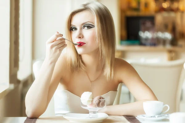 Una mujer en el restaurante está comiendo helado. —  Fotos de Stock