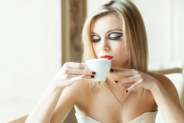 Una mujer en el restaurante está tomando café. — Foto de Stock