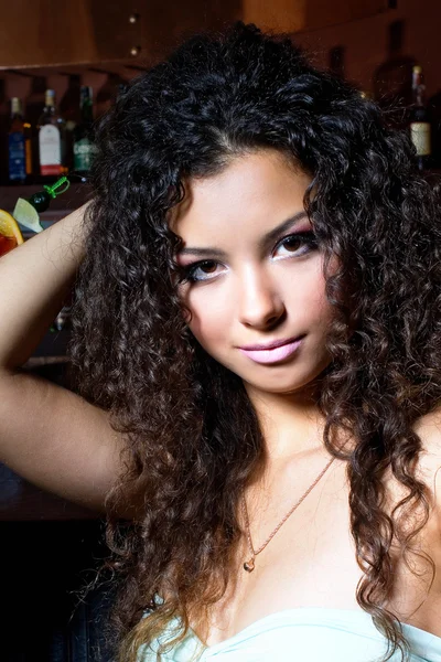 Женщина с вьющимися волосами в баре — стоковое фото