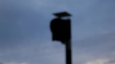 Gün batımında trafik ışıkları kırmızı yanıp sönüyor