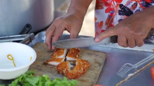Thaise keuken. Vrouw snijdt een stuk kip — Stockvideo