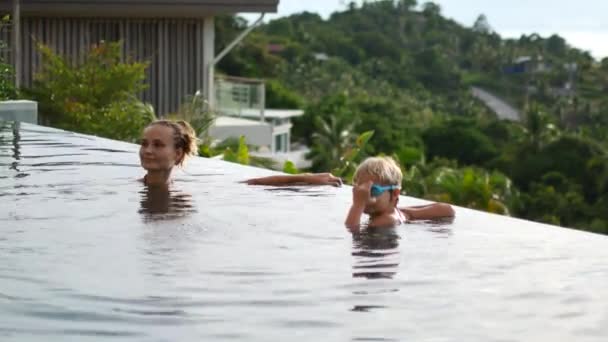 Mamá y su hija nadan en la piscina — Vídeo de stock
