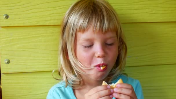 ブロンドの女の子はクッキー、肖像画を食べる — ストック動画