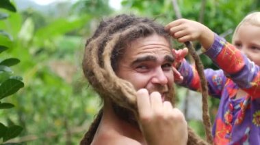 Kız babasının saçını kesti. Kızım, babaların saçlarını kesiyor.