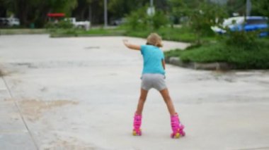 8 yaşındaki kız, otoparkta paten kayıyor.