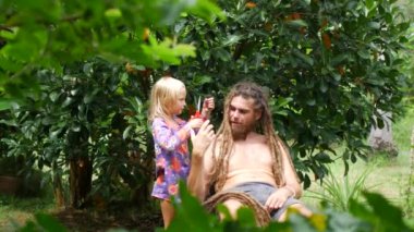 Kız babasının saçını kesti. Kızım, babaların saçlarını kesiyor.