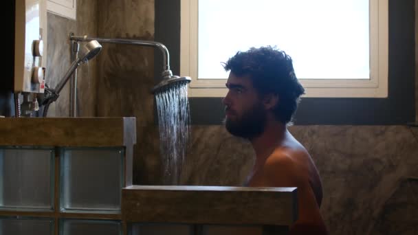 Мужчина думает принять душ или нет — стоковое видео