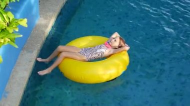 Kız ve sarı şişme yüzük su parkında..