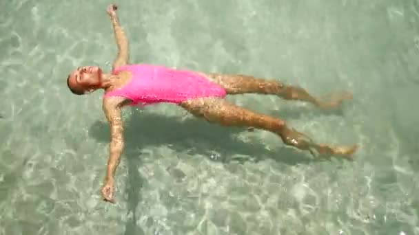 Μια Λεπτή Γυναίκα Ροζ Κοστούμι Απολαμβάνει Τις Διακοπές Στη Θάλασσα — Αρχείο Βίντεο