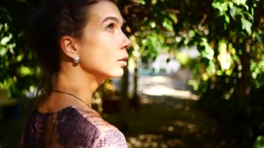 Güneş ışınlarıyla aydınlatılmış sakin bir yüz ifadesine sahip bir kadının portresi..