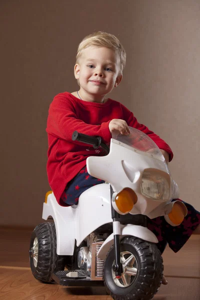 Gelukkige jongen op speelgoed motorfiets — Stockfoto