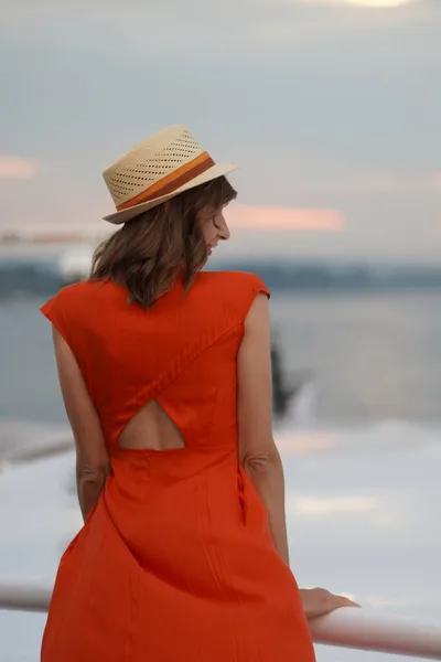 船の上に立つ長い赤いドレスと夏の帽子の女性 — ストック写真