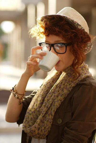 Hipster meisje drinken koffie buitenshuis — Stockfoto