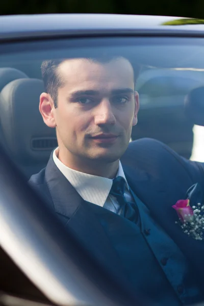 Handsome young groom in a car — Stock Photo, Image