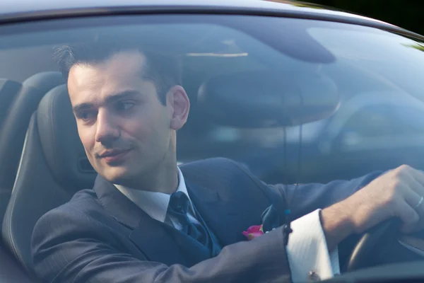 Handsome young groom in a car — Stock Photo, Image