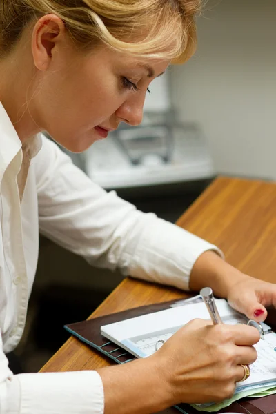Office worker woman writing in diary — Stock Photo, Image